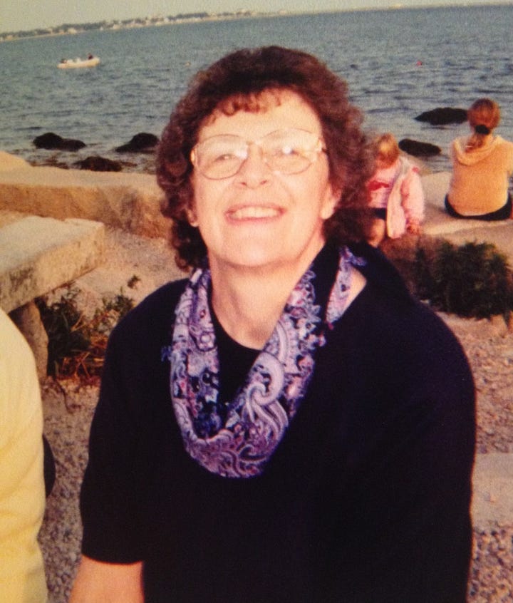 A series of photos of Vickie and her mother Sue. One is of Vickie as a baby and her mother sitting behind her on a couch, another is Sue with a black sweater and a purple scarf; a third is from an MS fundraiser and says "Friends of Sue" and features a photo of Sue in shorts and tee shirt at a beach in Aruba; and the fourth is of Vickie wearing a graduation cap and gown, smiling in a photo with her mother.
