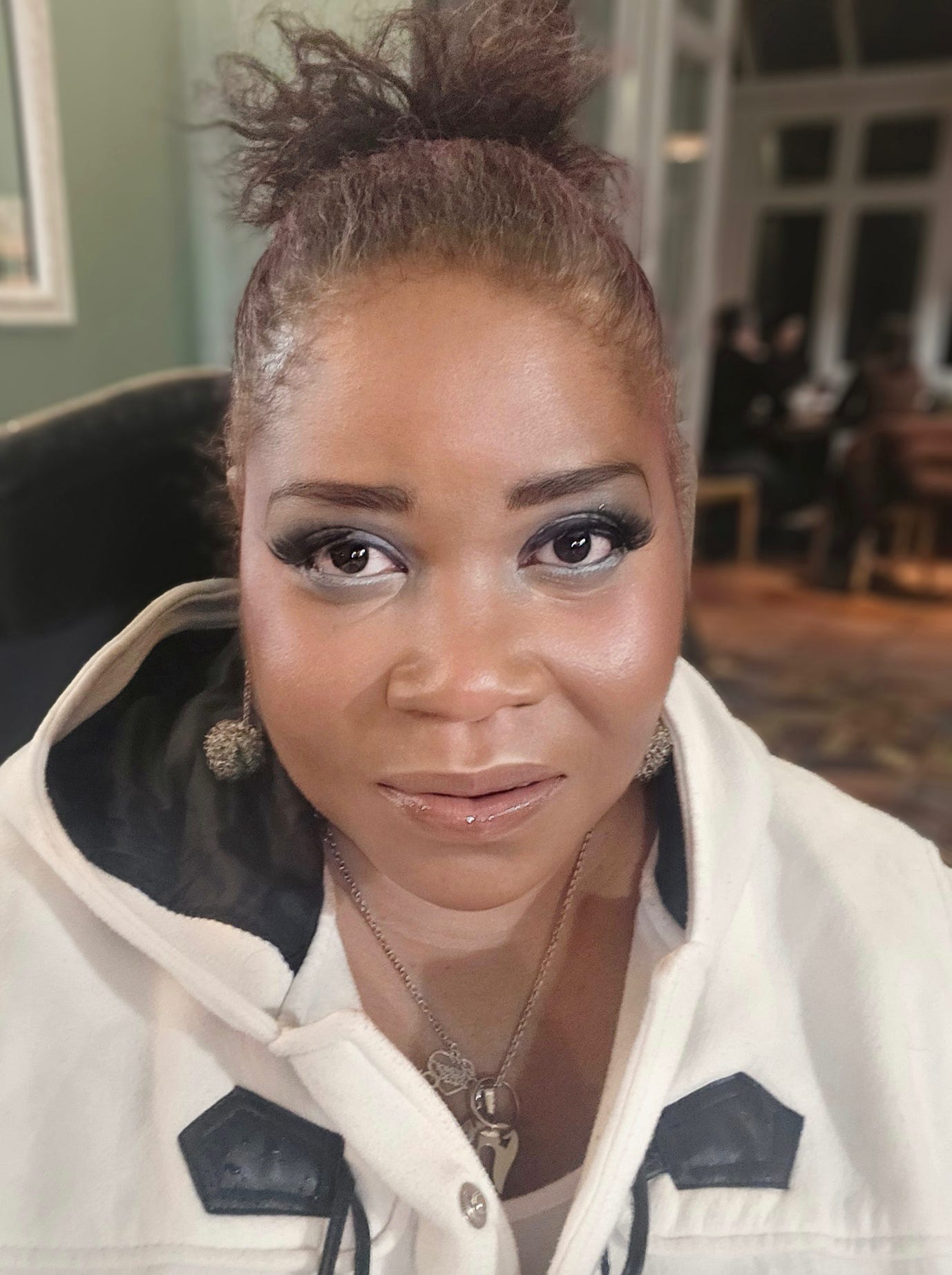 A person with a bun in a white and black jacket