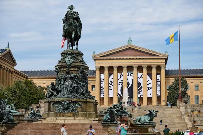 Statues in front of ornate Greek Revival-style building with sign that says 'Philadelphia Art Museum'