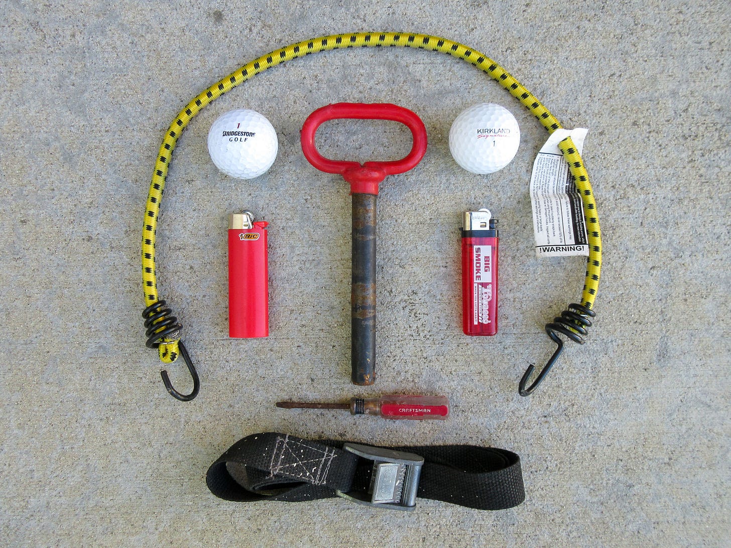 Bungie cord, golf balls, lighters, and a screwdriver Bungie cord, golf balls, lighters, and a screwdriver