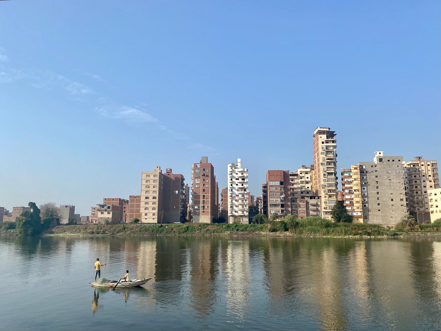 A fishing boat on the Nile in front of apartment buildings