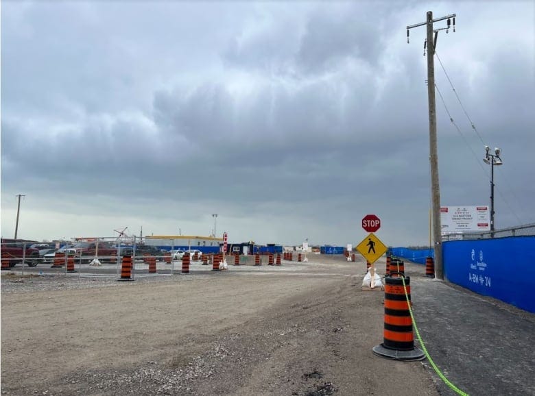 Construction pilons line a dirt road.