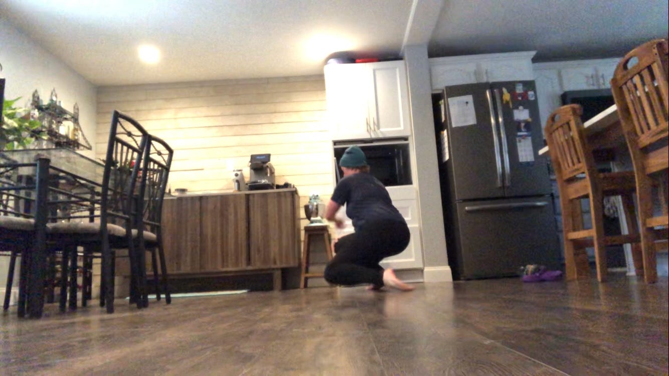 A person dances in a kitchen.