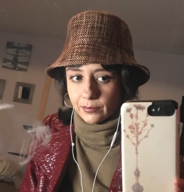 Author wearing a brown tweed bucket hat in a mirror selfie.
