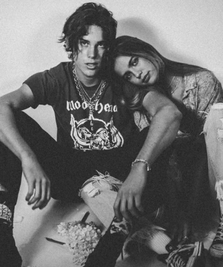 This may contain: a man and woman sitting next to each other on the floor with shoes in front of them