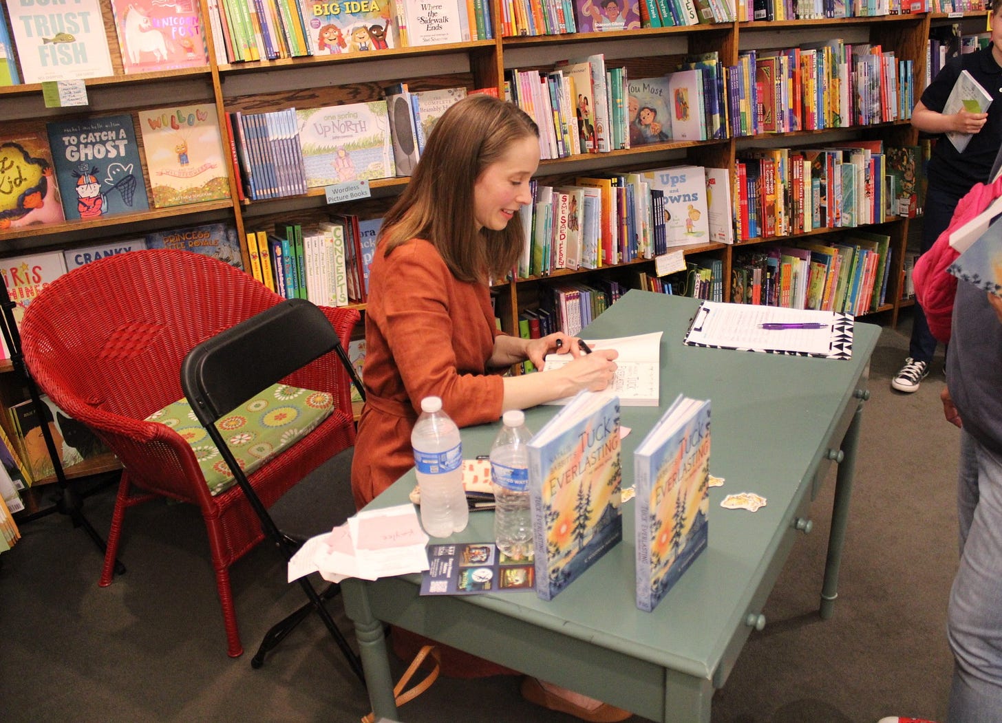 Photo of graphic novelist K. Woodman-Maynard at her release party at Red Balloon Bookshop in Minnesota, celebrating her launch of Tuck Everlasting the Graphic Novel. 