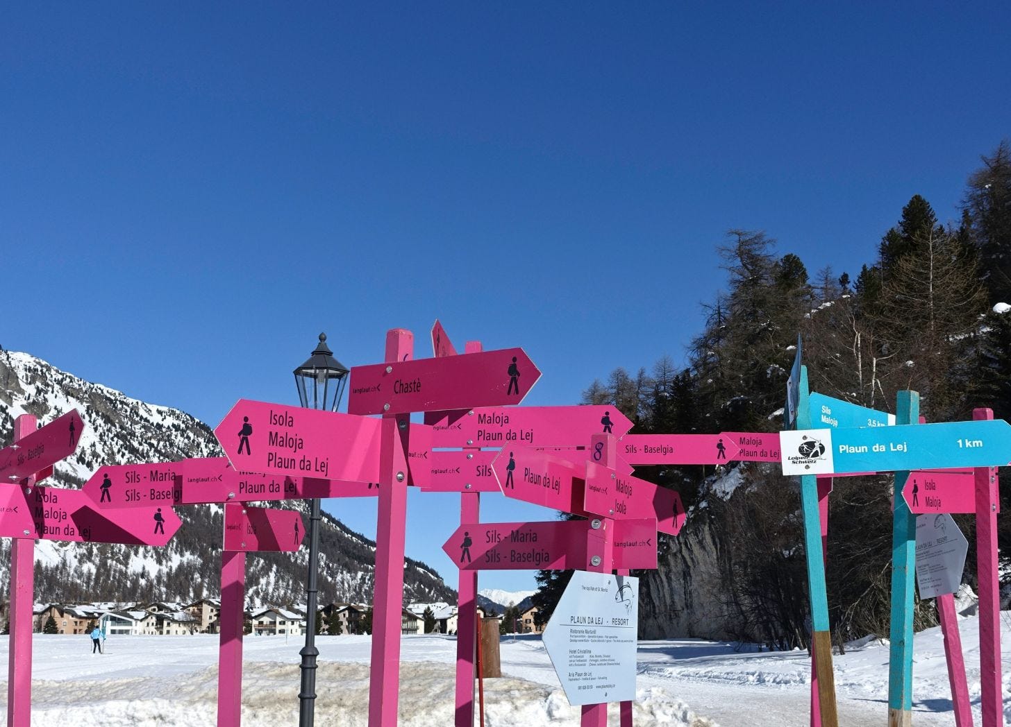 Bright pink directional signage pointing in multiple directions, showing traveler confusion and lack of clear destination guidance.