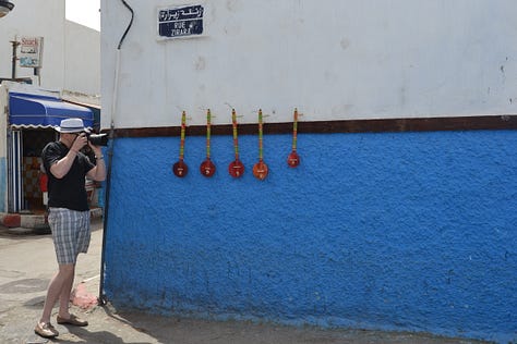 Scenes from Morocco featuring traditional architecture, vibrant souks, and cultural details - from geometric mosaic floors and colorful markets to local artisans and the famous goats in argan trees.
