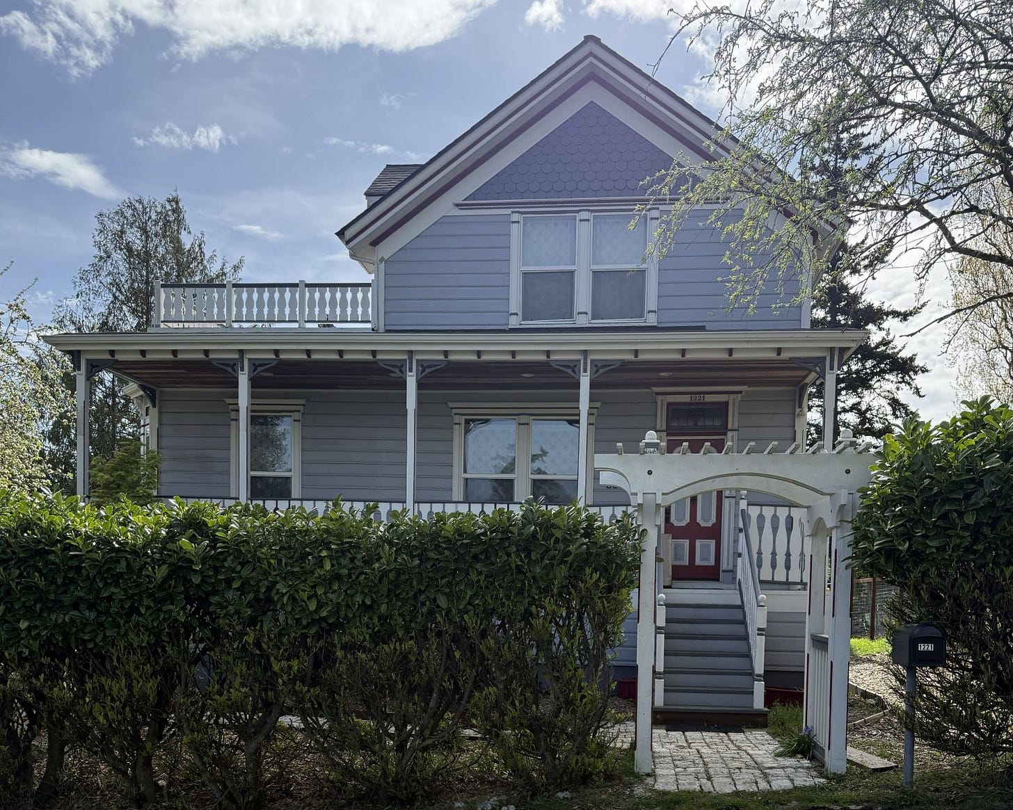An asymmetrical Victorian house with widows walk and broad porch.