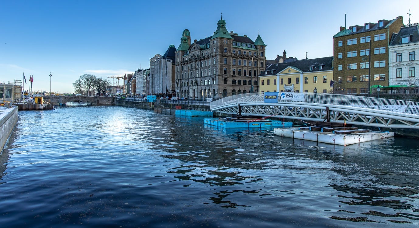A body of water with buildings and a bridge

AI-generated content may be incorrect.