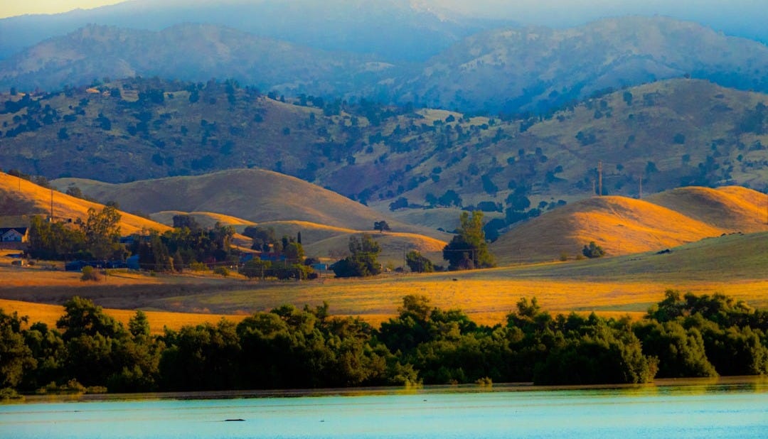 a view of a mountain range with a lake in the foreground