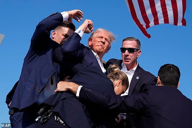Trump mouthed the word 'fight' at supporters as blood spattered across his face Trump mouthed the word 'fight' at supporters as blood spattered across his face
