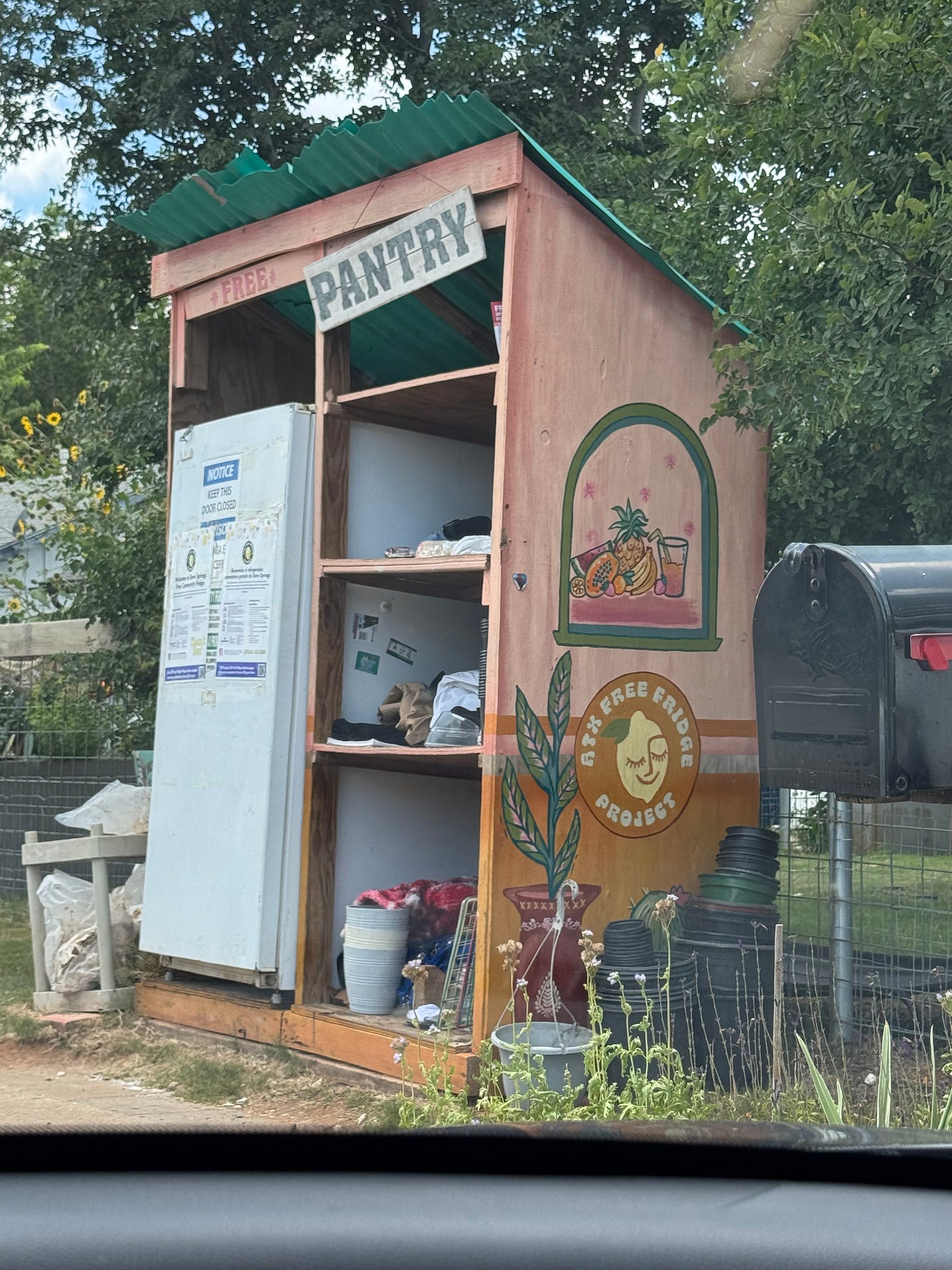 a shaded food pantry with a fridge and other pantry items. on the side it reads ATX Free Fridge a shaded food pantry with a fridge and other pantry items. on the side it reads ATX Free Fridge