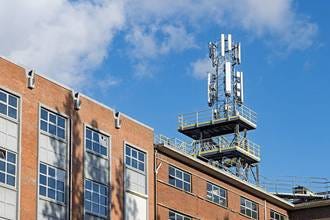 cell phone tower with multiple antennas. A cell phone tower with multiple antennas sits atop a red brick building against a bright blue sky, highlighting modern telecommunications infrastructure. cell towers stock pictures, royalty-free photos & images cell phone tower with multiple antennas. A cell phone tower with multiple antennas sits atop a red brick building against a bright blue sky, highlighting modern telecommunications infrastructure. cell towers stock pictures, royalty-free photos & images