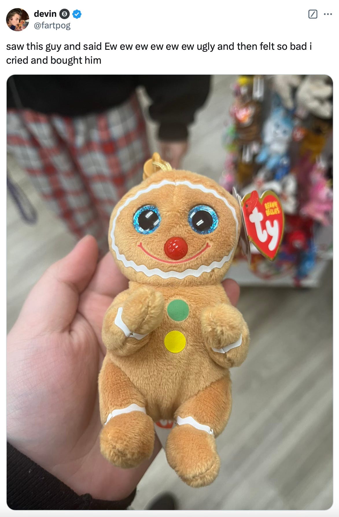 Picture of a tweet from @fartpog that says “saw this guy and said Ew ew ew ew ew ew ugly and then felt so bad I cried and bought him” above a picture of a derpy looking stuffed animal that is maybe some type of gingerbread person held in someone’s hand in a store. 