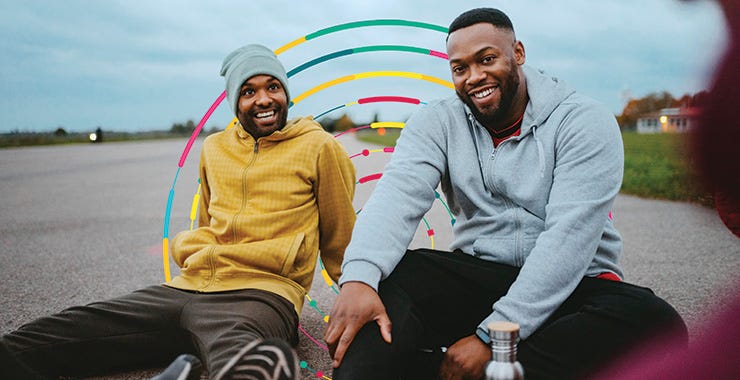 two men smiling and sitting near each other 