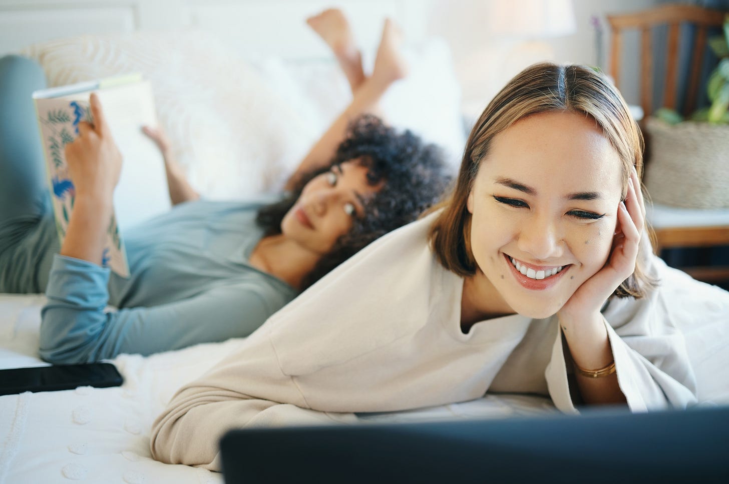two beautiful women reading in bed