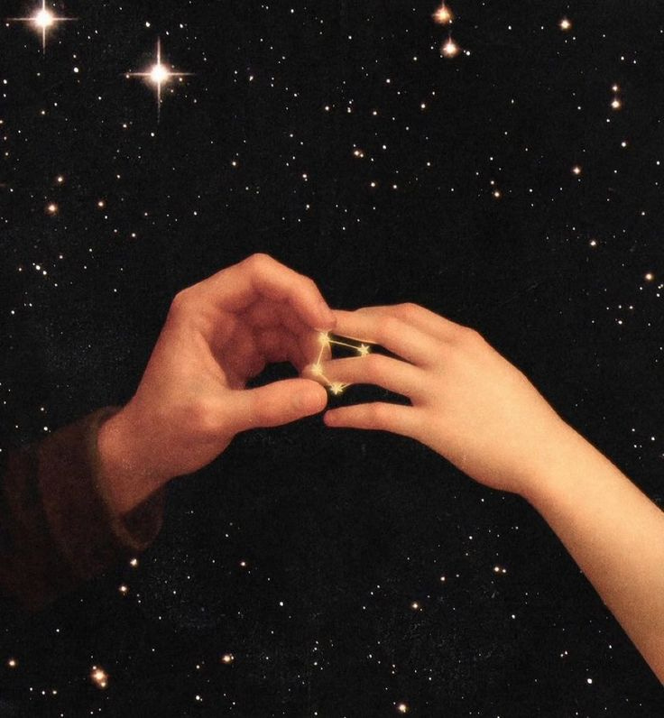 This may contain: two hands reaching towards each other with stars in the background