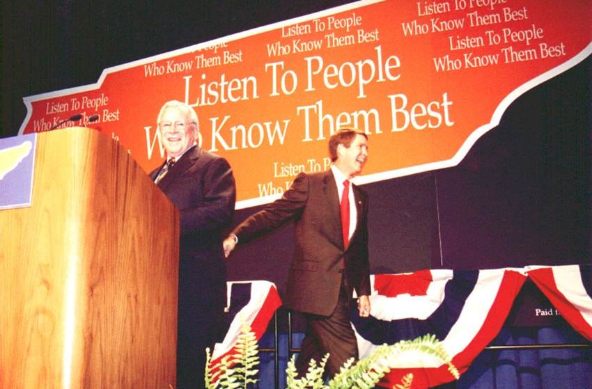 A person in a suit and tie standing at a podium

AI-generated content may be incorrect.