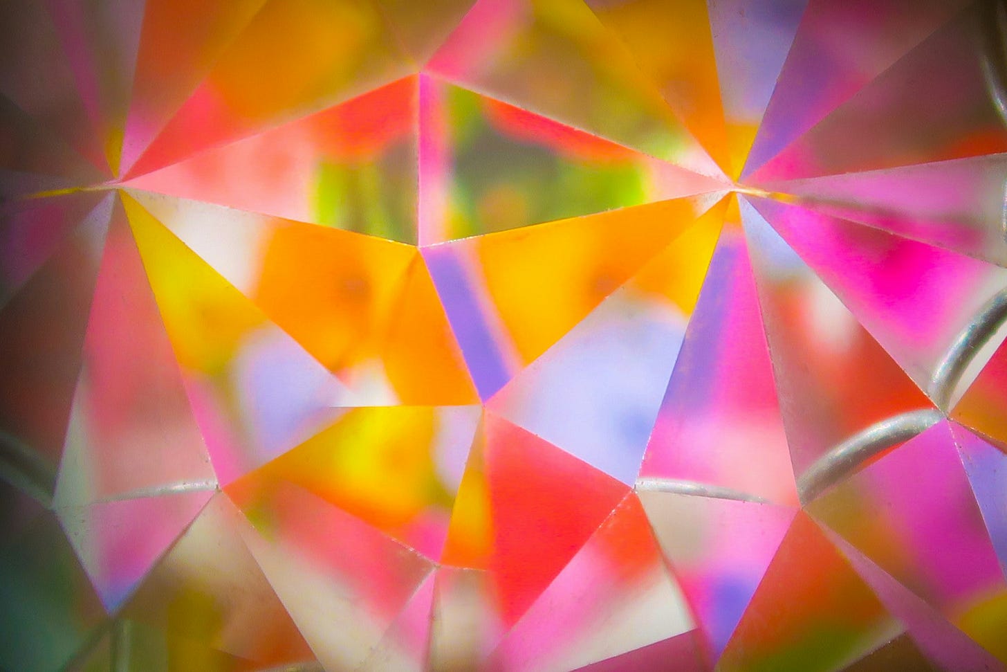 A brightly coloured series of triangles that gives the impression of looking at a garden through a kaleidoscope