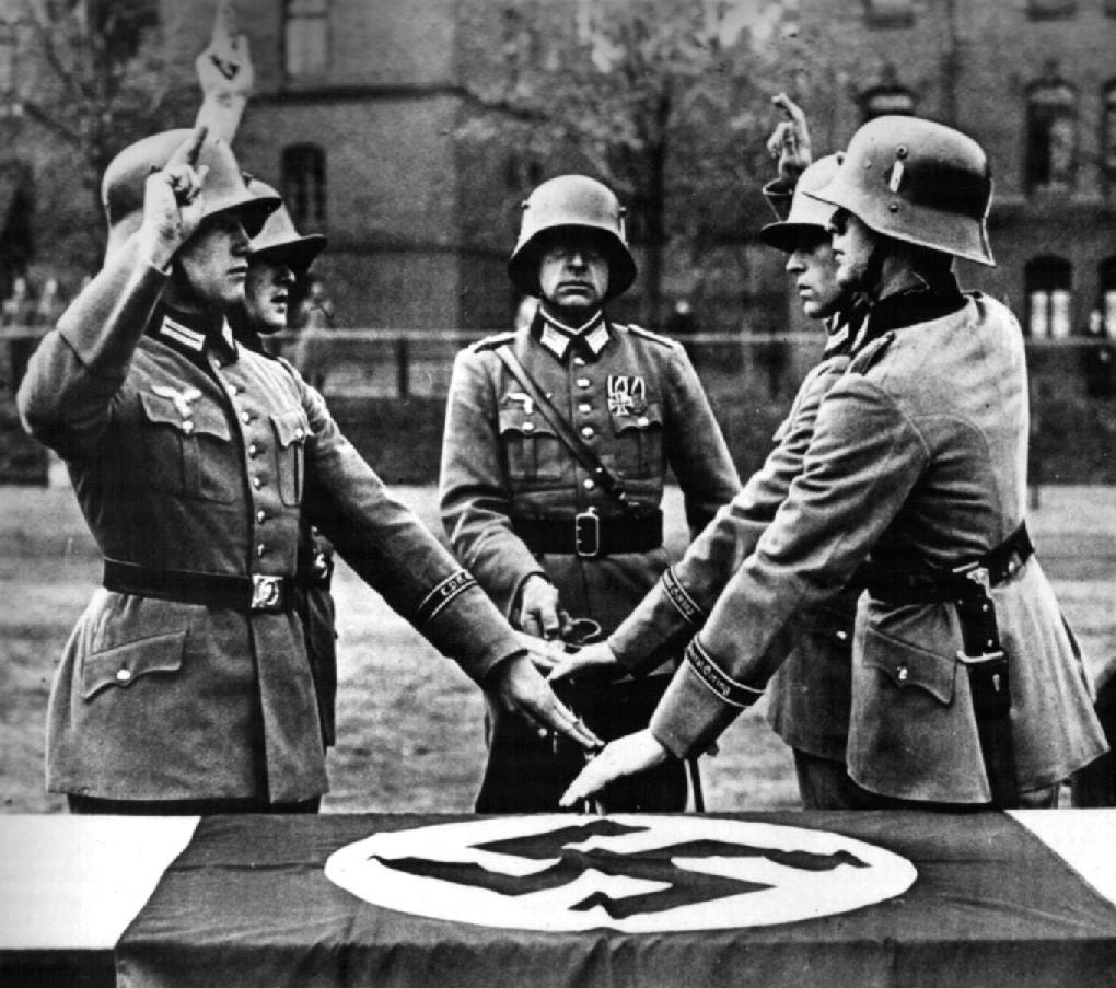 Third Reich Wehrmacht soldiers swearing allegiance to A.H. on a swastika flag
