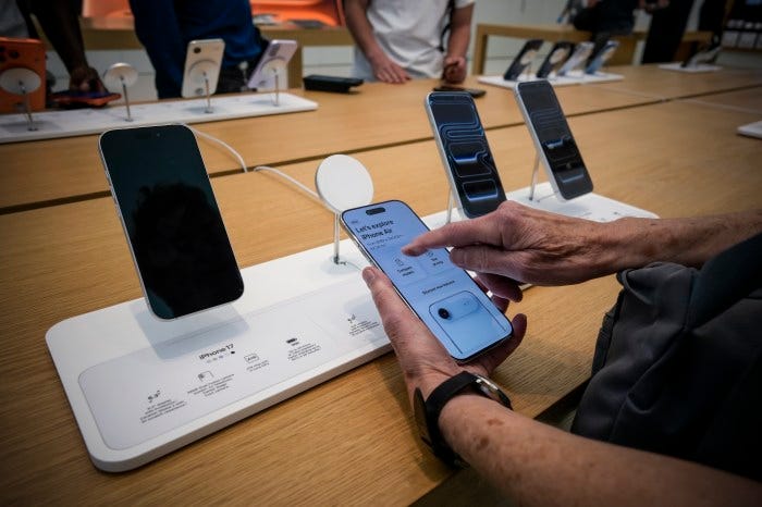A customer examines an iPhone at an Apple store.