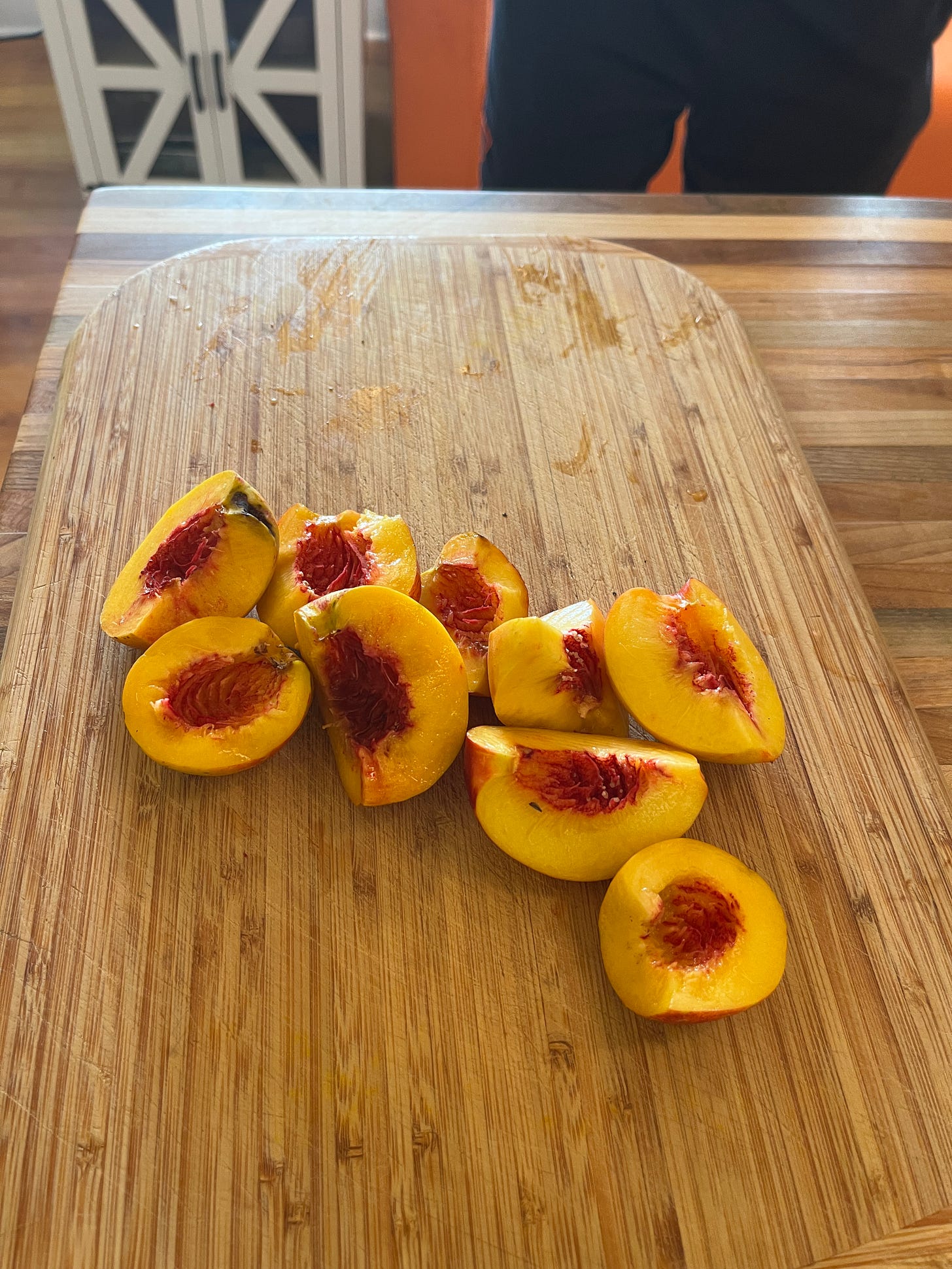 About half a dozen nectarines cut open sitting on a cutting board