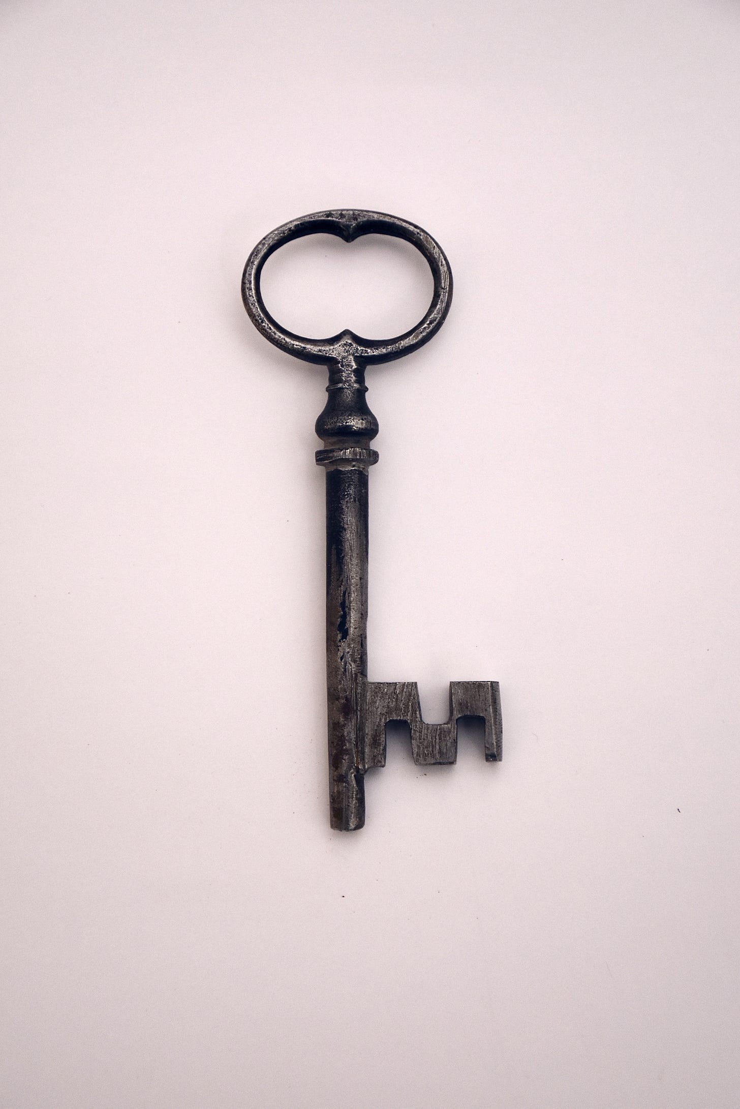 an old fashioned black key on a pink background an old fashioned black key on a pink background