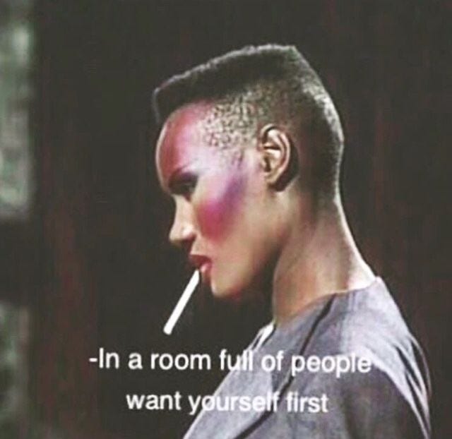 Image of Grace Jones' profile, with bright pink highlighter. She stands in black leather, looking down with a cigarette hanging out of her mouth. The caption below says "In a room full of people, want yourself first." Image of Grace Jones' profile, with bright pink highlighter. She stands in black leather, looking down with a cigarette hanging out of her mouth. The caption below says "In a room full of people, want yourself first."