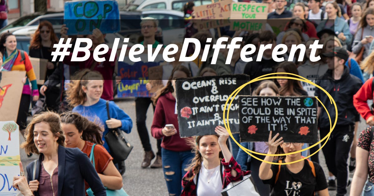 A crowd of protesters with the believe different hashtag overlayed