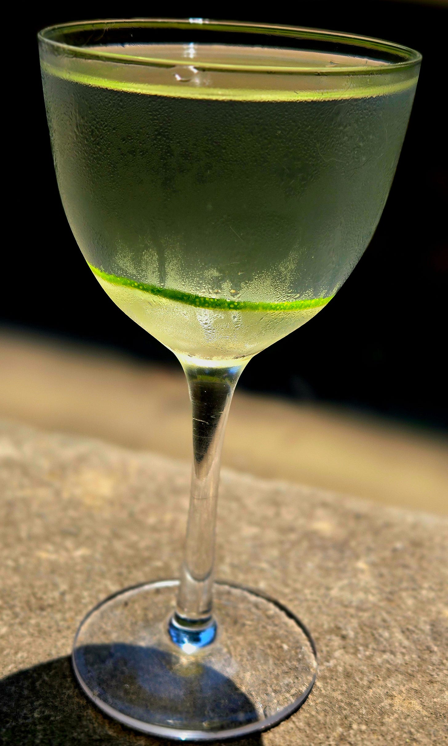 Sideview of the L’Étoile Libre cocktail sitting atop a stone wall. Sideview of the L’Étoile Libre cocktail sitting atop a stone wall.