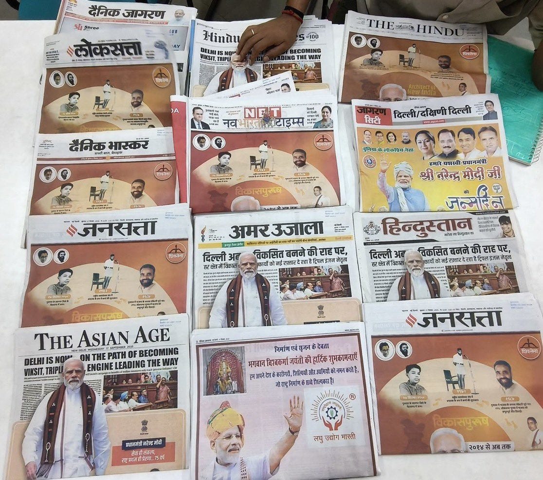 Multiple newspapers spread on a table, including Dainik Jagran, The Hindu, The Times of India, Navbharat Times, Amar Ujala, Hindustan, Jansatta, and The Asian Age. Headlines and images feature Narendra Modi, with some papers showing him in traditional attire or waving. Text in Hindi and English is visible on the front pages.