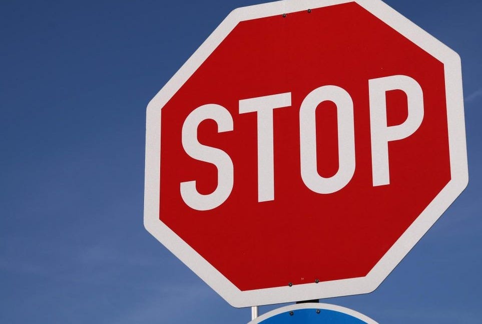 Red STOP sign with white block letters and a blue sky background. Stop negative internal dialogue to help overcome writer's block. Red STOP sign with white block letters and a blue sky background. Stop negative internal dialogue to help overcome writer's block.