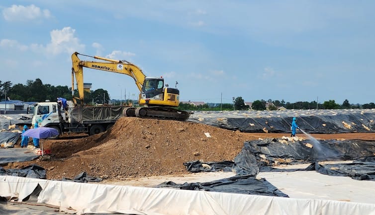 Large equipment move piles of contaminated dirt. Large equipment move piles of contaminated dirt.
