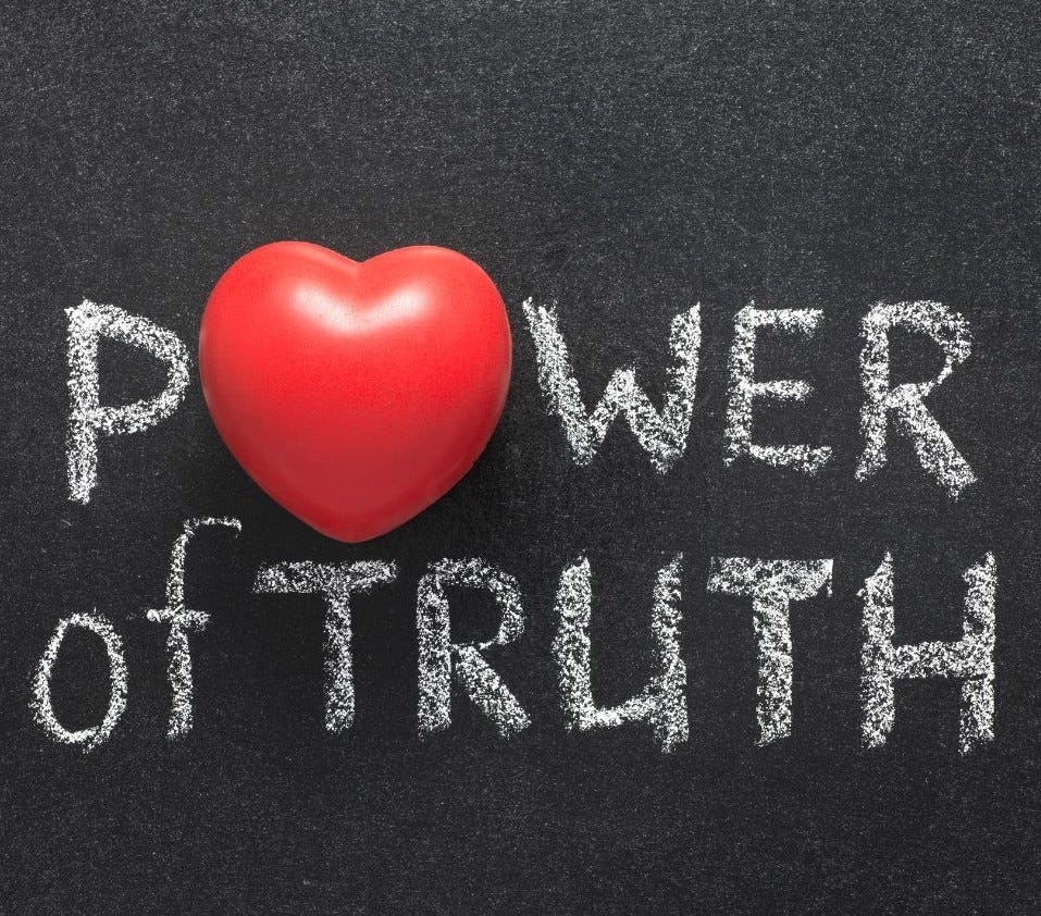 A blackboard on which is written in white chalk, "Power of Truth". The "O" on Power appears as a bright red heart.