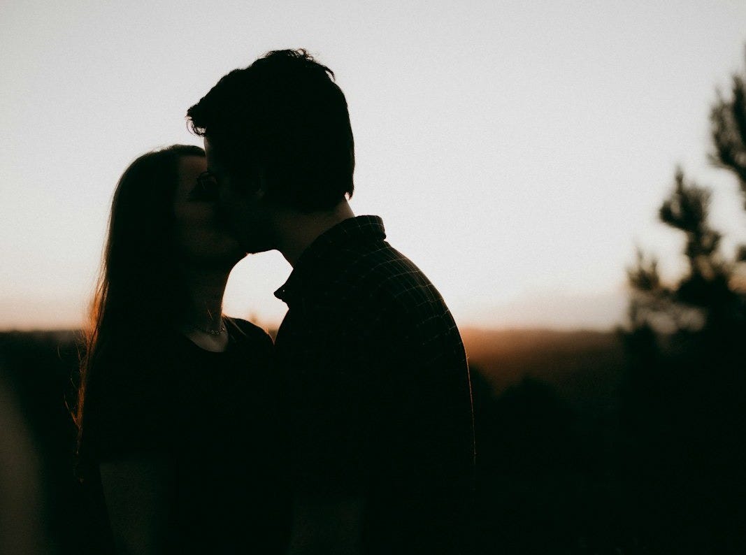 Couple shares a kiss as the sun sets. Couple shares a kiss as the sun sets.