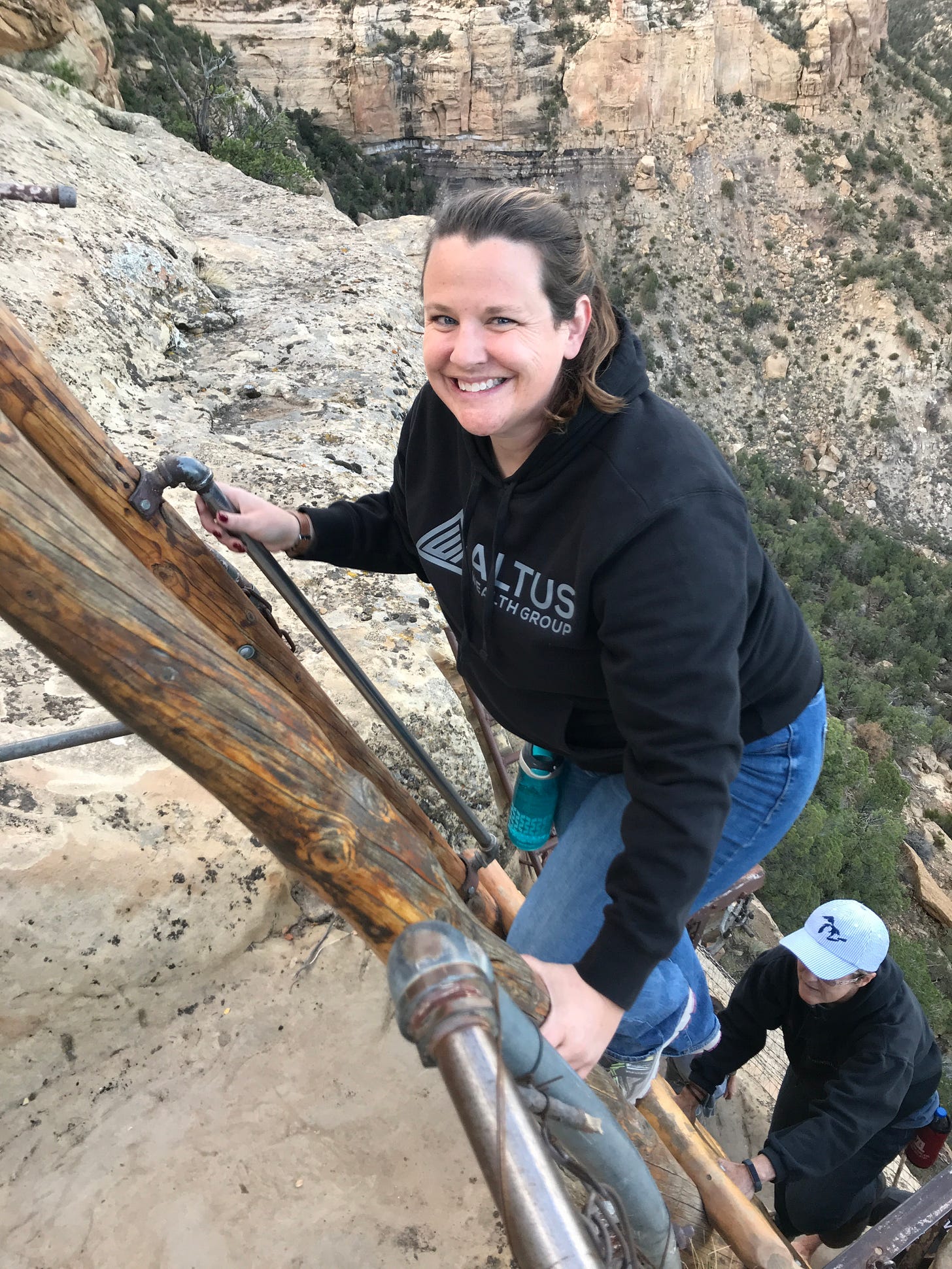 Woman climbing up cliff face on ladder