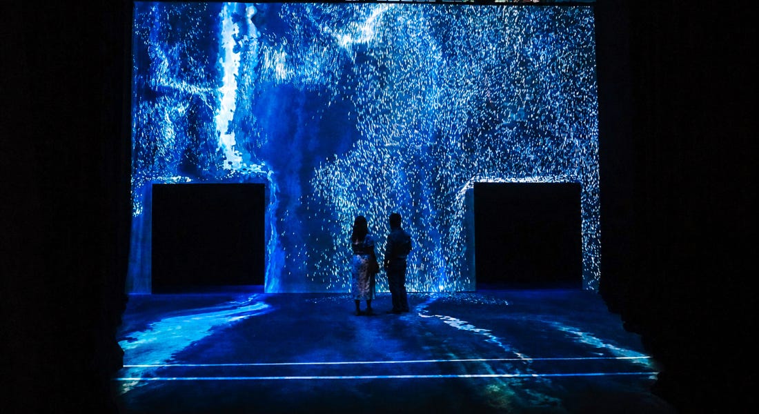 A blue installation with two doors and two people stood in the middle A blue installation with two doors and two people stood in the middle