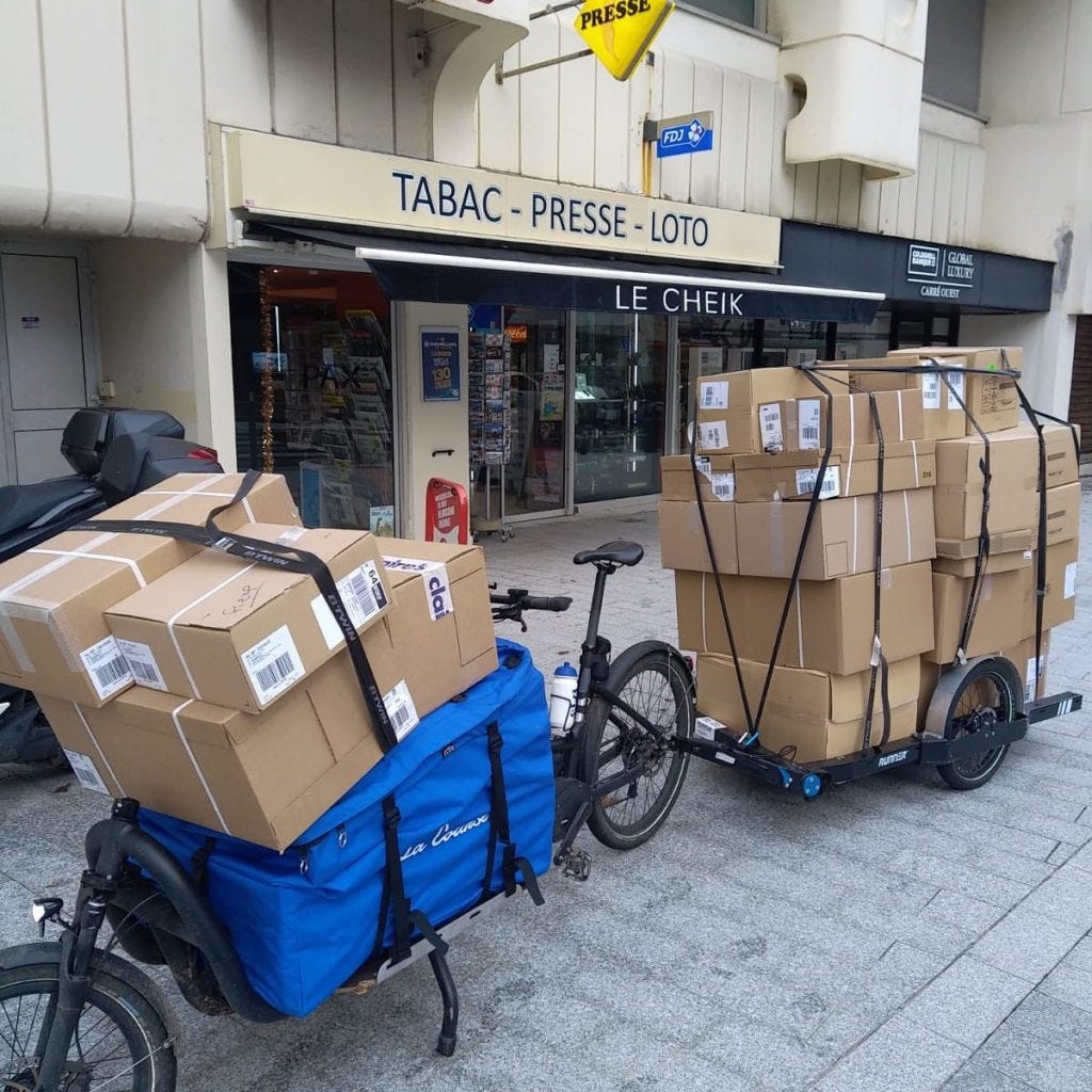 Vélo cargo avec une remorque très chargée.