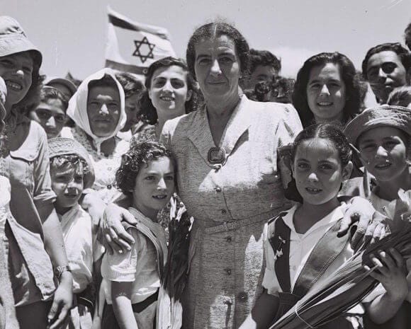 Golda Meir poses with a picture with the children of Kibbutz Shefaim, July 24, 1950 (Photo: Wikimedia)