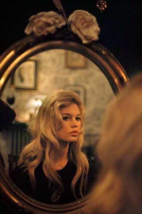 This may contain: a woman is looking in the mirror and always loving what you see with her reflection