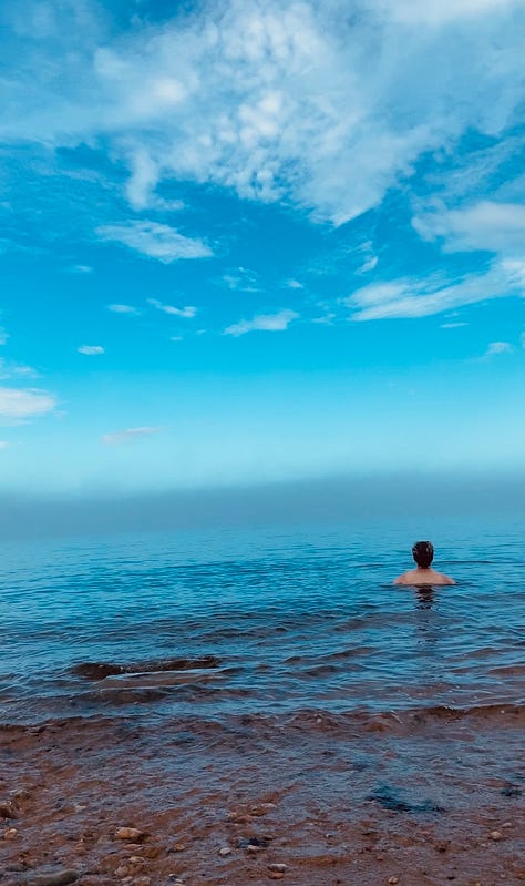 three photos of a person emerging into the ocean's calm blue water