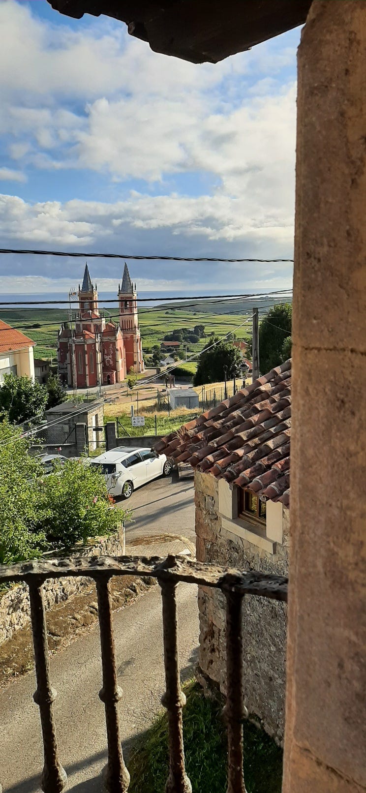 View over rooftiles towards church and distant sea
