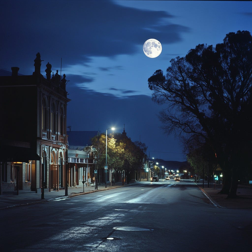 A quiet night scene on Mair Street in Ballarat, Victoria, Australia. The street is mostly empty, flanked by heritage buildings and softly lit by street lamps. A brilliant full moon hangs in the sky, illuminating the scene and casting shadows of trees along the footpath. A quiet night scene on Mair Street in Ballarat, Victoria, Australia. The street is mostly empty, flanked by heritage buildings and softly lit by street lamps. A brilliant full moon hangs in the sky, illuminating the scene and casting shadows of trees along the footpath.