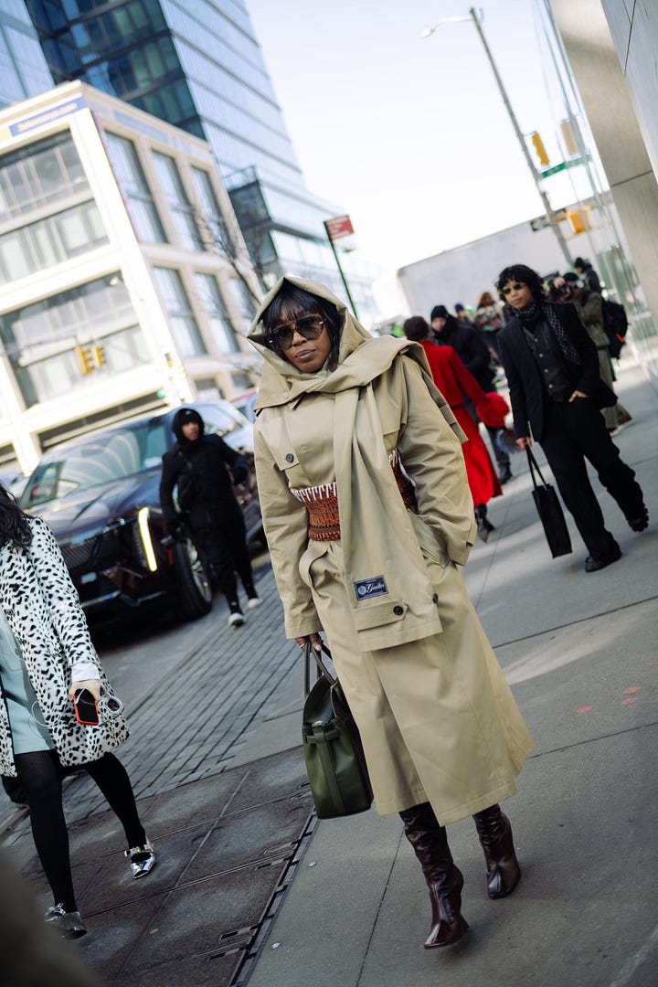 Street style image of a fashionable woman in olive outerwear during NYFW; close-up of a burgundy vintage leather jacket styled for fashion week.