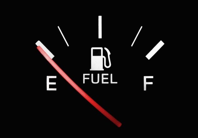 A black fuel tank gauge with the red needle pointing to E as a symbol of a writers empty emotional tank A black fuel tank gauge with the red needle pointing to E as a symbol of a writers empty emotional tank