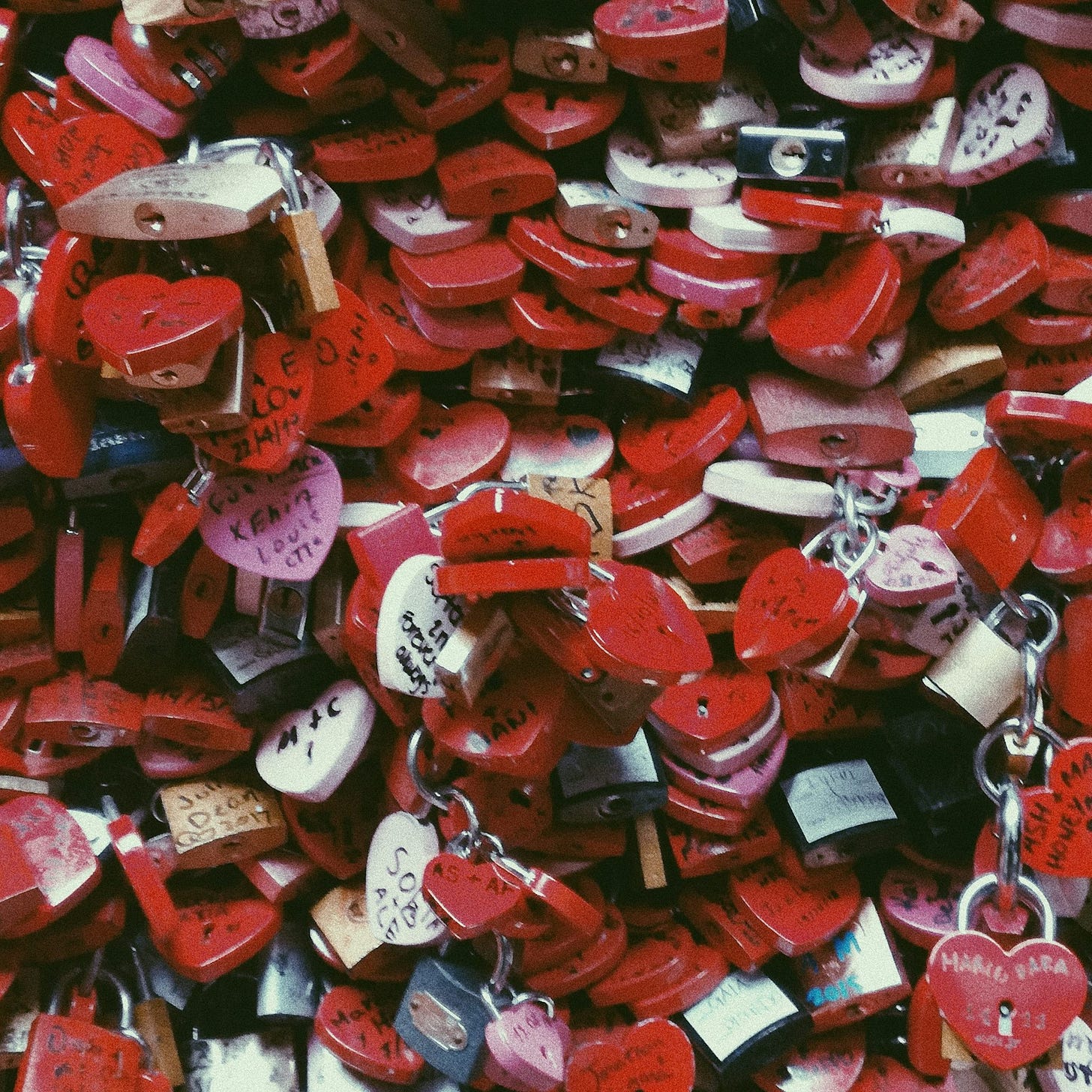 a pile of red heart shaped padlocks