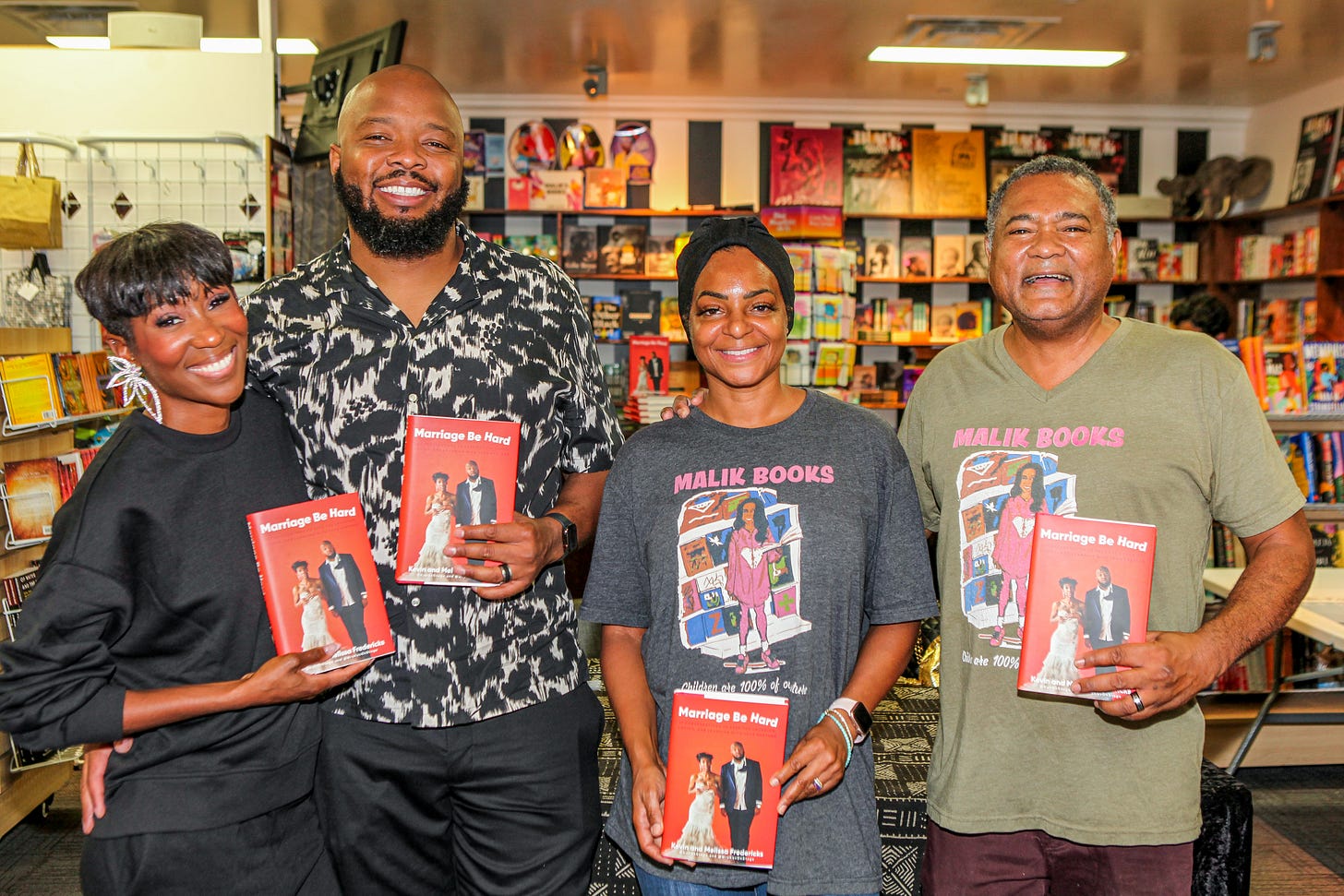 Four people holding books at a Malik Books literacy partnership event Four people holding books at a Malik Books literacy partnership event