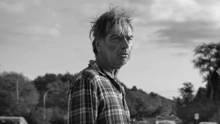 a person standing beside a road with vehicles in the background a person standing beside a road with vehicles in the background