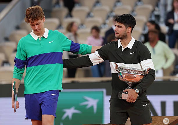 Carlos Alcaraz of Spain holds the Coupe des Mousquetaires trophy as he speaks with runner-up Jannik Sinner of Italy following his victory in the...
